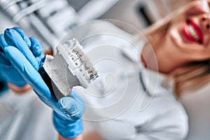 Technical shots of model on a dental prothetic laboratory. Dentist hand with plaster model photo