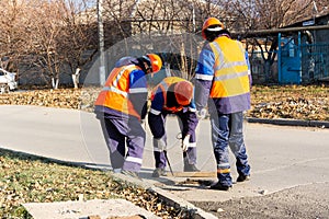 Technical utility workers carry out maintenance in the sewer manhole