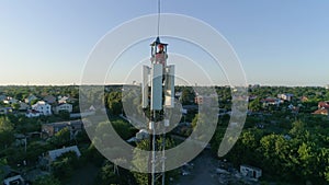 Technical worker on top cellular antenna show thumbs up, aerial shot of telecommunication tower