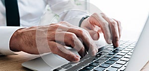 Technical writer typing laptop keyboard, closeup of hands