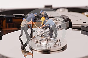Technicial team miniature people repairing hard drive
