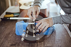 Technician adjusting acoustic guitar neck, Close-up