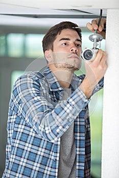 Technician adjusting cctv camera on wall