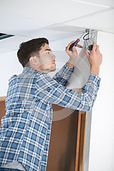 Technician adjusting cctv camera on wall