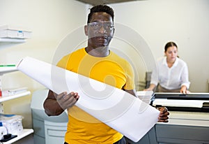 Technician african american working of printing house with stack of notebooks in her hands