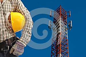 Technician against telecommunication tower, painted white and re