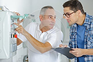 Technician and apprentice fixing photocopier machine