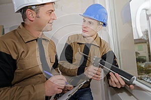 Technician and apprentice using silicon gun