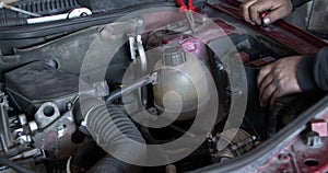 Technician in a car repair service repairs the vehicle`s wiring fault