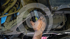 Technician change car oil filter under car. Mechanic doing car service and maintenance. Oil and fuel filter changing. Car maintena