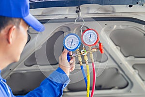 Technician check car air conditioning system refrigerant recharge, Repairman holding monitor tool to check and fixed car air