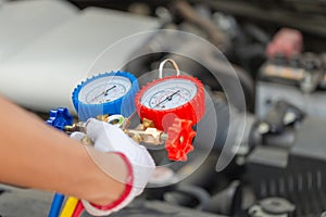 Technician check car air conditioning system refrigerant recharge, Repairman holding monitor tool to check and fixed car air