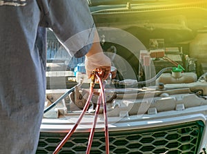 Technician checking air conditioner in engine room of eco car , cleaning air conditioner of car