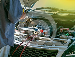 Technician checking air conditioner in engine room of eco car , cleaning air conditioner of car