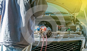 Technician checking air conditioner in engine room of eco car , cleaning air conditioner of car