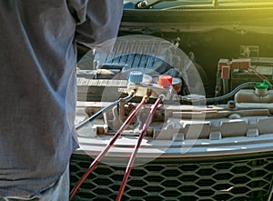 Technician checking air conditioner in engine room of eco car , cleaning air conditioner of car