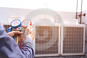 Technician is checking air conditioner ,measuring equipment