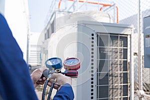 Technician is checking air conditioner ,measuring equipment air conditioners