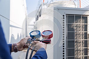 Technician is checking air conditioner ,measuring equipment air conditioners