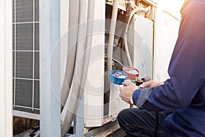 Technician is checking air conditioner ,measuring equipment for filling air conditioners