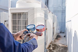 Technician is checking air conditioner ,measuring equipment for filling air conditioners