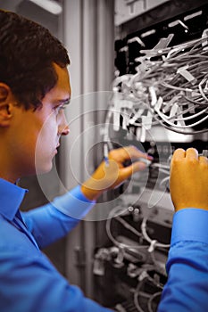 Technician checking cables in a rack mounted server