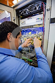 Technician checking cables in a rack mounted server