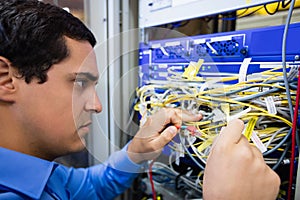 Technician checking cables in a rack mounted server