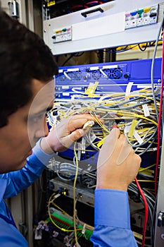 Technician checking cables in a rack mounted server