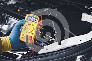 Technician checking DC voltage stable with digital multimeter