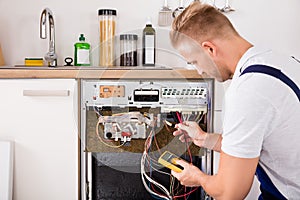 Technician Checking Dishwasher With Digital Multimeter