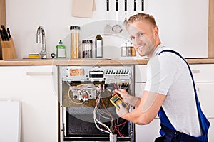Technician Checking Dishwasher With Digital Multimeter