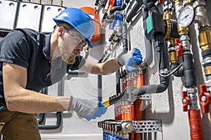 The technician checking the heating system in the boiler room.