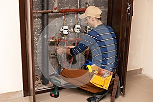 The technician checking the heating system in the boiler room with tablet in hand