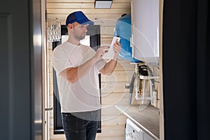 The technician checking the heating system in the boiler room with tablet in hand