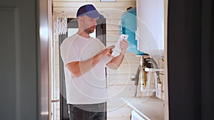 The technician checking the heating system in the boiler room with tablet in hand