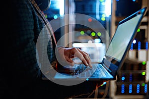 IT technician checking the servers vitals using laptop computer photo