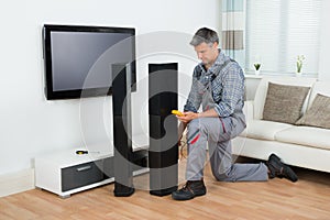Technician Checking TV Speaker With Multimeter photo