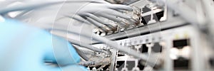 Technician checks the quality of internet connection against background cable hub close-up