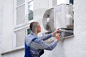 Technician Cleaning And Repairing Air Condition Appliance