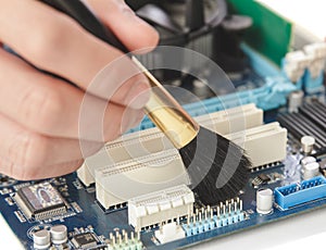 technician cleaning up the hardware of computer using brush