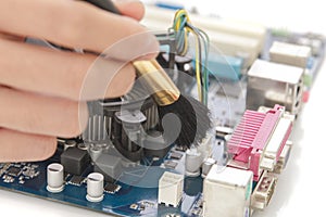 Technician cleaning up the hardware of computer using brush