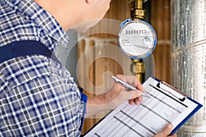 Technician With Clipboard Reading Water Meter