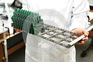 Technician with computer circuit board with chips. Spare parts and components for computer equipment. Production of