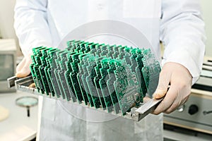 Technician with computer circuit board with chips. Spare parts and components for computer equipment. Production of