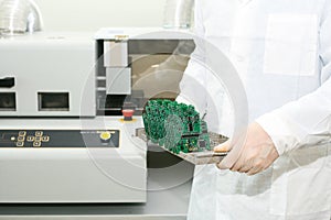 Technician with computer circuit board with chips. Spare parts and components for computer equipment. Production of