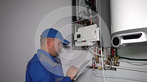 Technician with computer set gas boiler system and show thumbs up smiling