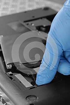 Technician connecting hard drive HDD cable to a laptop computer.