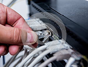 Technician connecting network cables to switches. Connecting cables