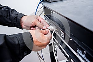 Technician connecting network cables to switches. Connecting cables